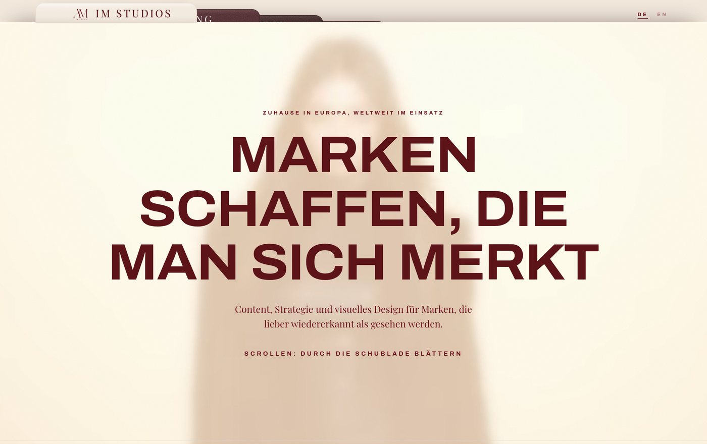 Startseite von IM Studios: die Schlagzeile „Marken schaffen, die man sich merkt“ in weinroten Versalien auf cremefarbenem Grund